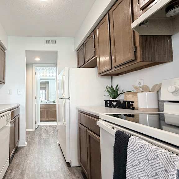 a kitchen with brown cabinets and a white fridge.