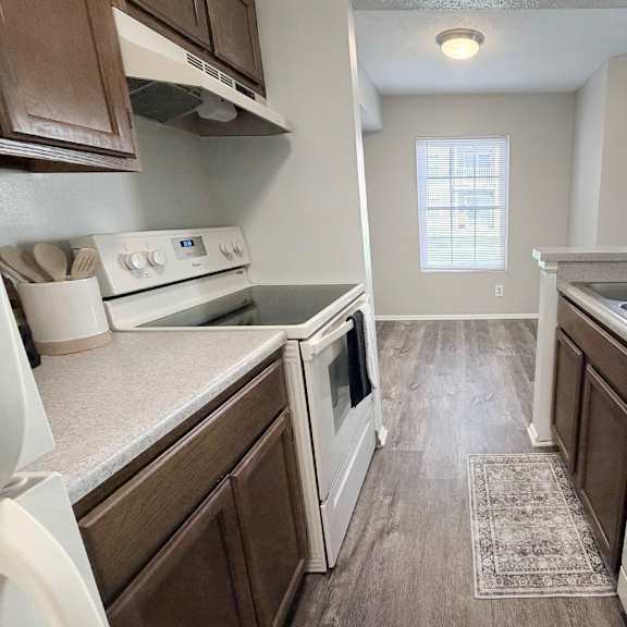 a kitchen with white appliances and brown cabinets.