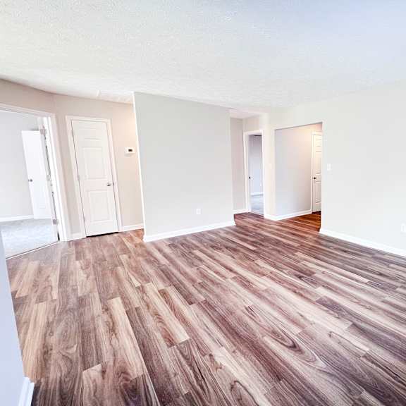a room with wooden flooring and white walls.