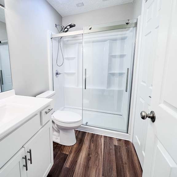 a white bathroom with a walk in shower.