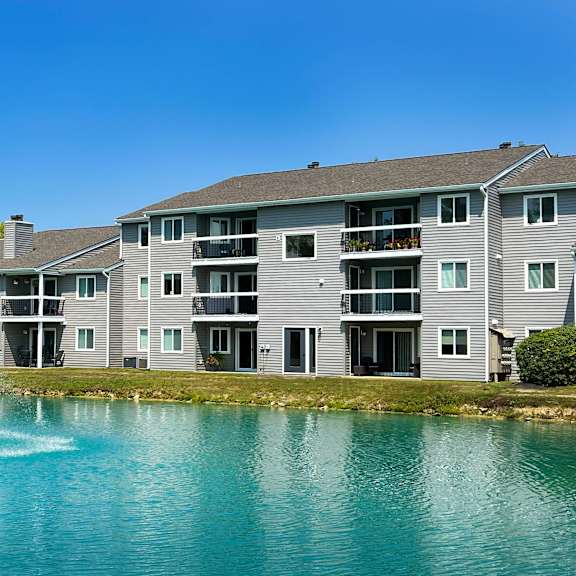 a fountain in a lake in front of an apartment building at deercross apartments, cincinnati, ohio