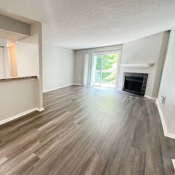 an empty living room with wood flooring and a fireplace at deercross apartments, ohio, 45236