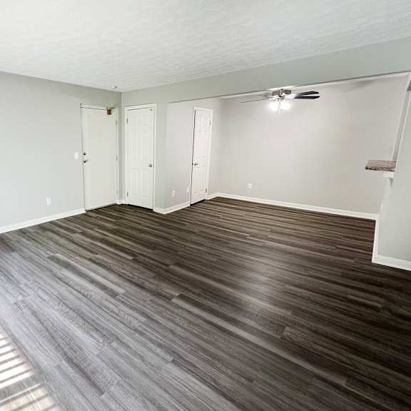 an empty living room with wood floors and white walls at fox run apartments, cincinnati