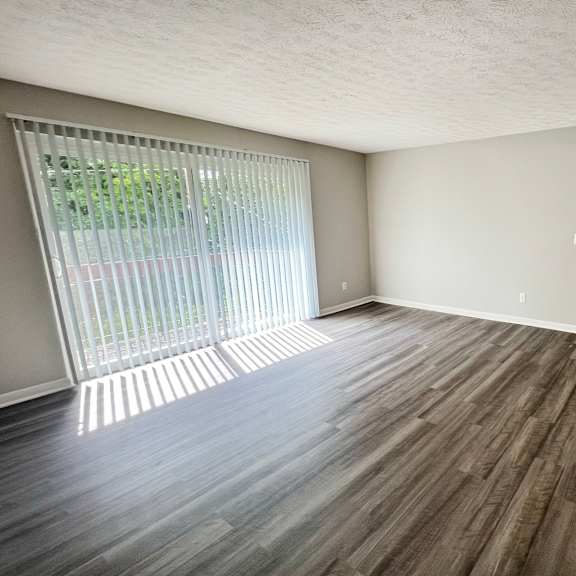 an empty living room with wood flooring and a window at fox run apartments, cincinnati