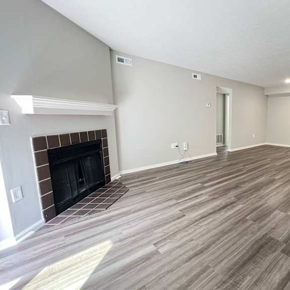 a living room with a fireplace and wooden floors at deercross apartments, cincinnati, oh 45236