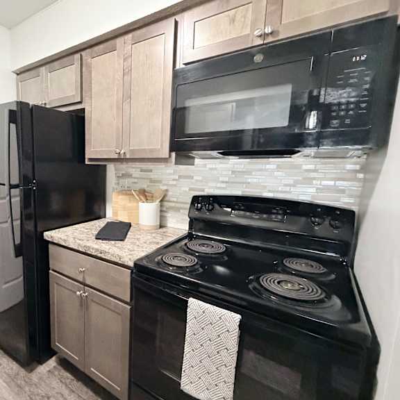 a black stove and refrigerator in a kitchen.