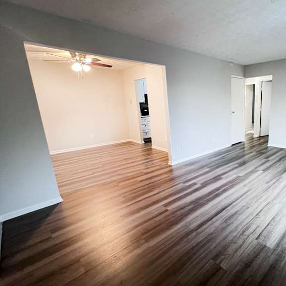 a room with wooden flooring and white walls.