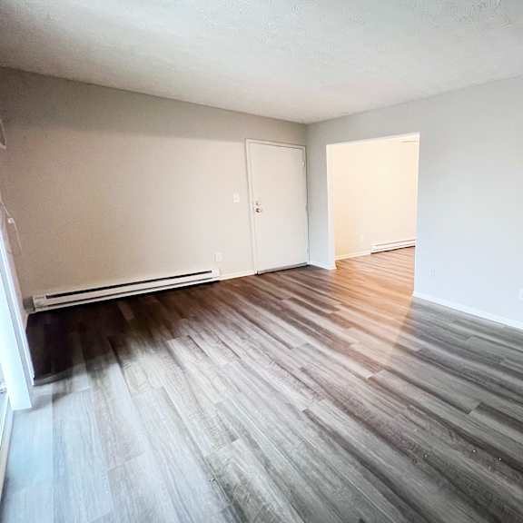 a room with wooden flooring and white walls.