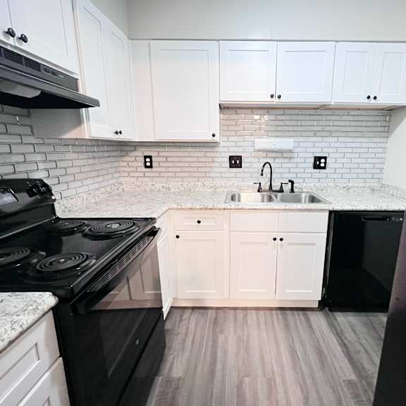 a kitchen with black appliances and white cabinets.