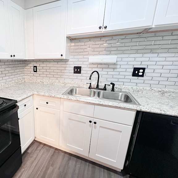 a kitchen with a black stove top oven and white cabinets.