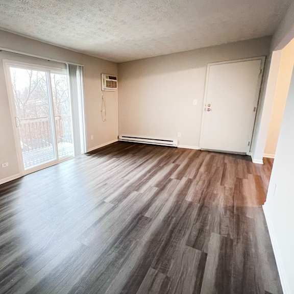a room with wooden flooring and white walls.