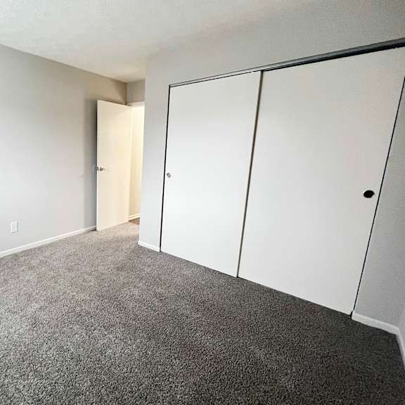 a room with a carpeted floor and a white door.