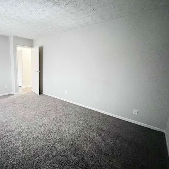 a room with a carpeted floor and a white door.