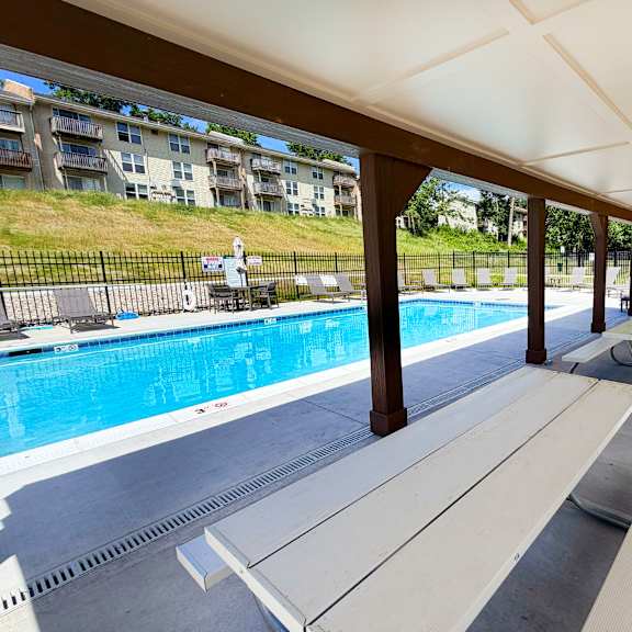 a pool area with a bench and a pool.