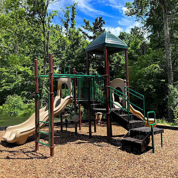 a playground with a green slide and a yellow slide.