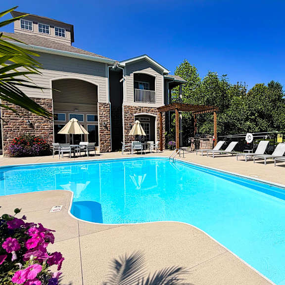 a pool with a slide and lounge chairs.