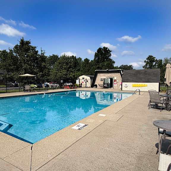 a large outdoor swimming pool with a blue tiled edge and a white line in the middle.
