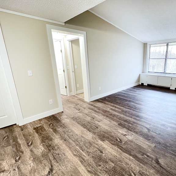 an empty living room with white walls and wood floors at wentworth estates apartments, florence, ky
