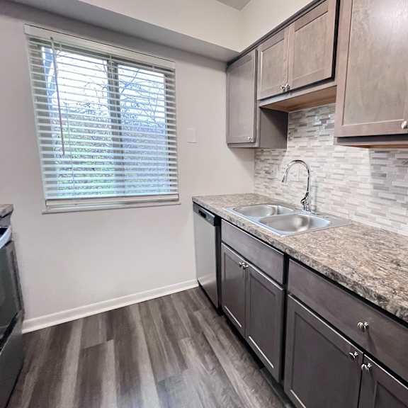 a kitchen with a granite countertop and wooden cabinets.
