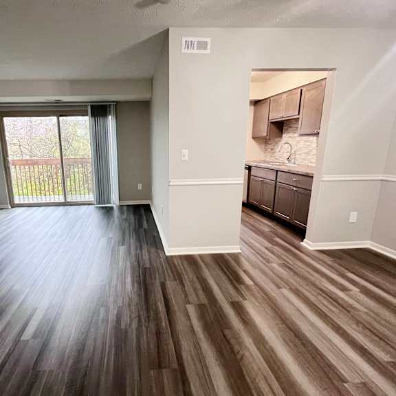 a room with wooden flooring and a sliding glass door.