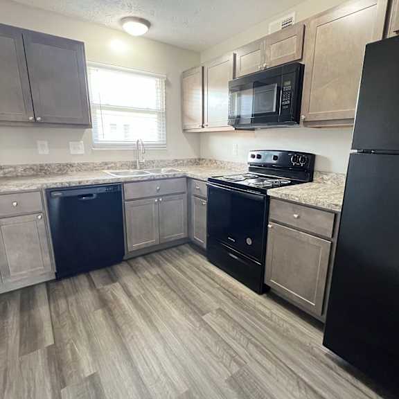 a kitchen with wood flooring and stainless steel appliances at revere village apartments, centerville, 45458