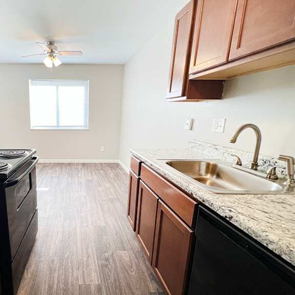 a kitchen with wooden cabinets and a black stove top oven.