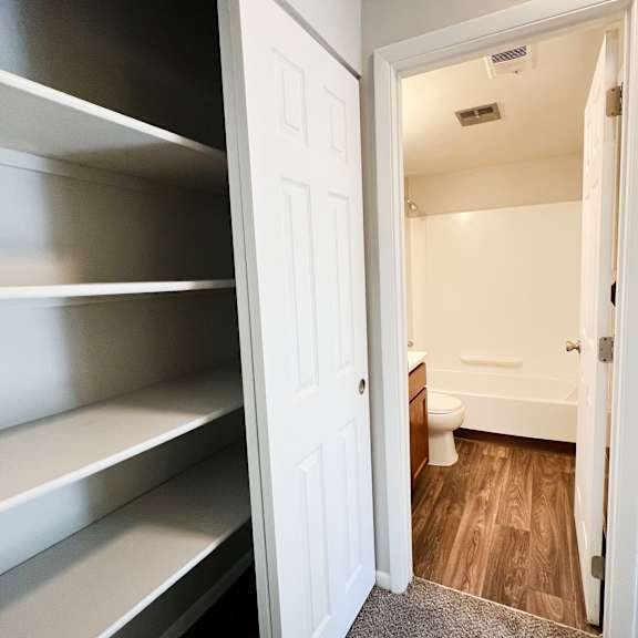 a white door is open to a small bathroom.