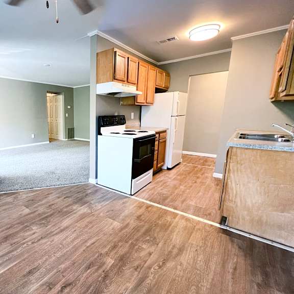 a kitchen with wood flooring and white appliances.