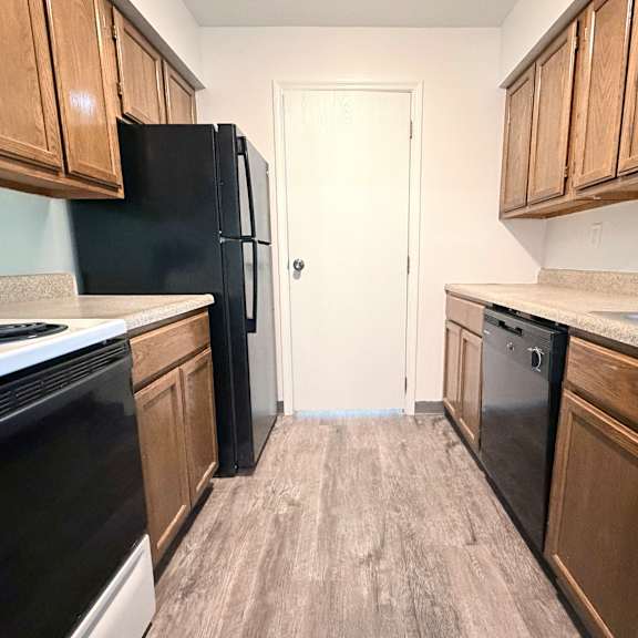a kitchen with black appliances and wooden cabinets.