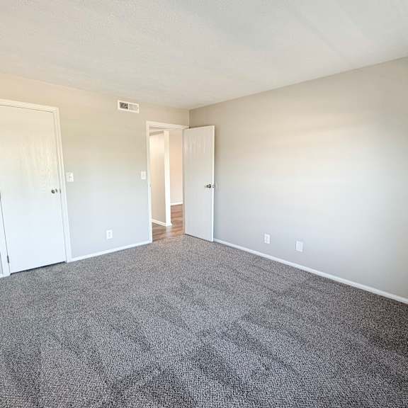 a room with grey carpet and white walls.