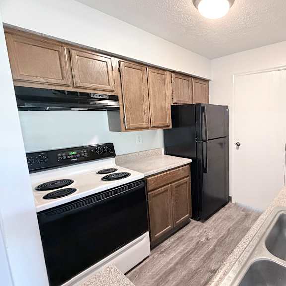 a kitchen with black appliances and wooden cabinets.