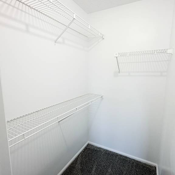 a white empty pantry with a black floor.
