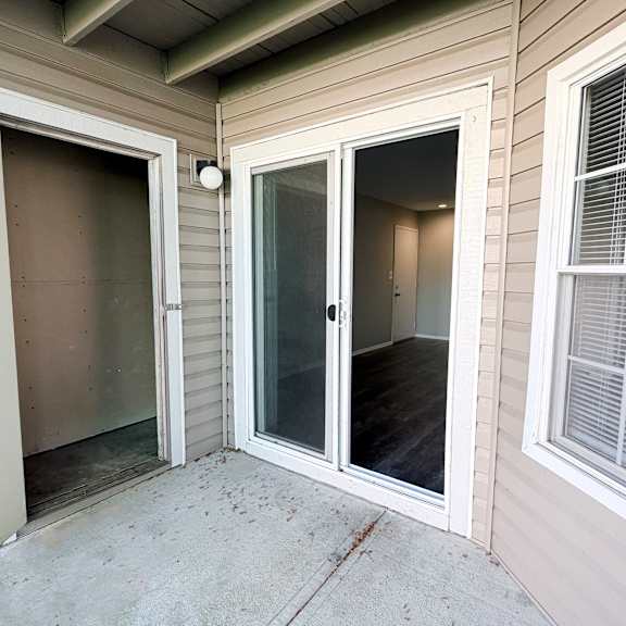 a patio area with a sliding glass door and a window.