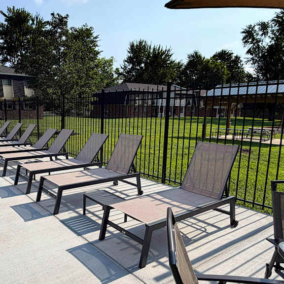 a row of sun loungers are on a concrete surface.