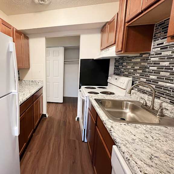 a kitchen with a white refrigerator and a white dishwasher.