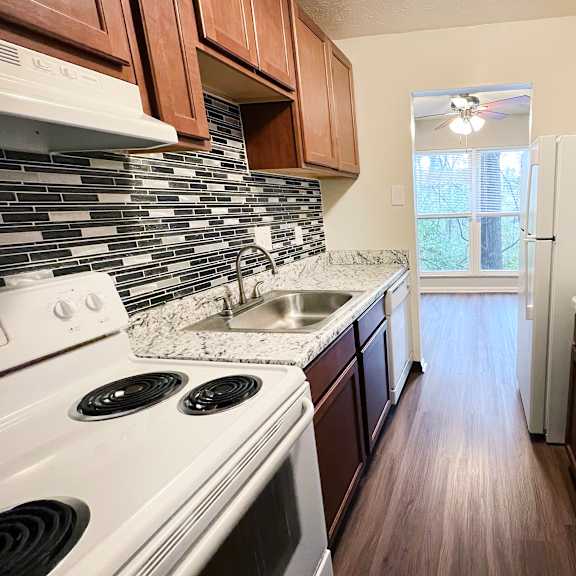 a kitchen with white appliances and brown cabinets.