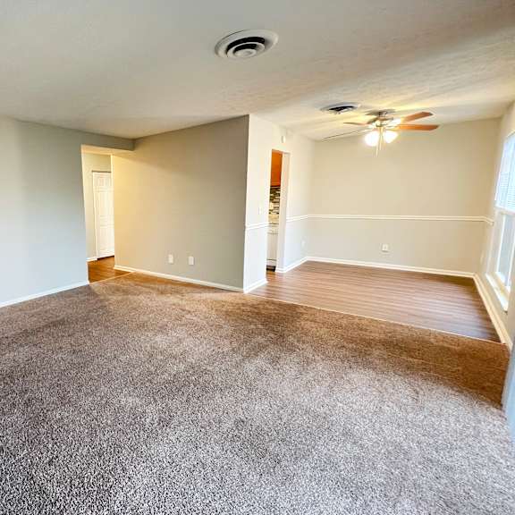 a room with a carpeted floor and a ceiling fan.