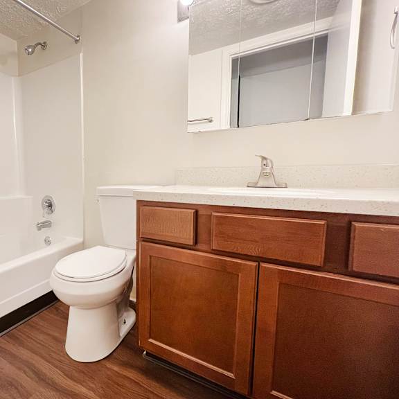 a white toilet sits in a bathroom next to a white bathtub.
