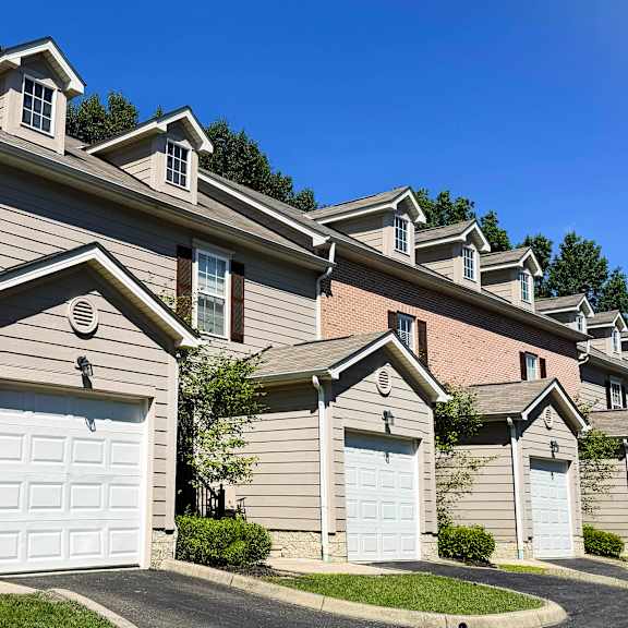 a row of houses with white garage doors.