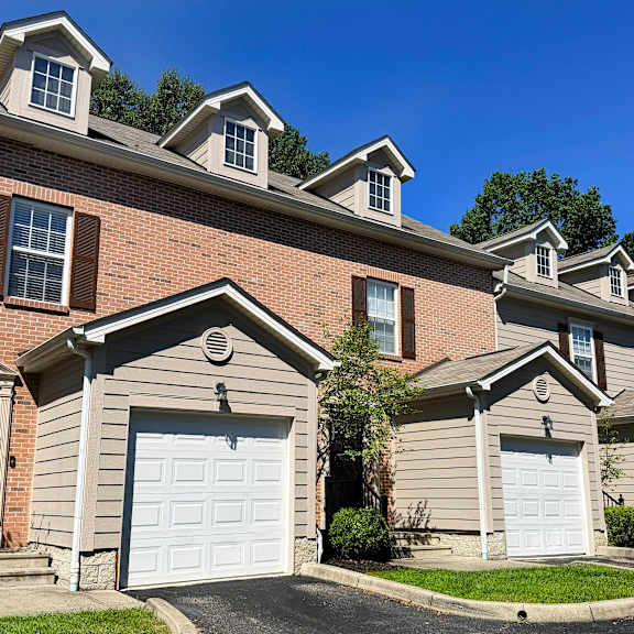 a row of houses with garages and a clear blue sky.