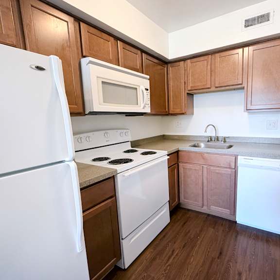 a kitchen with white appliances and wooden cabinets.
