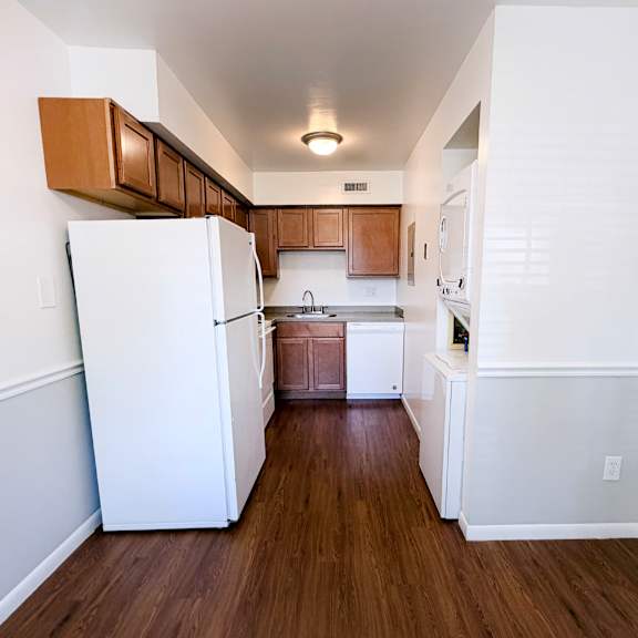 a kitchen with white appliances and wooden cabinets.