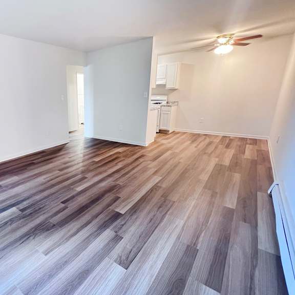 a room with wooden flooring and a white wall.