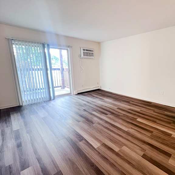 a room with wooden flooring and a sliding glass door.