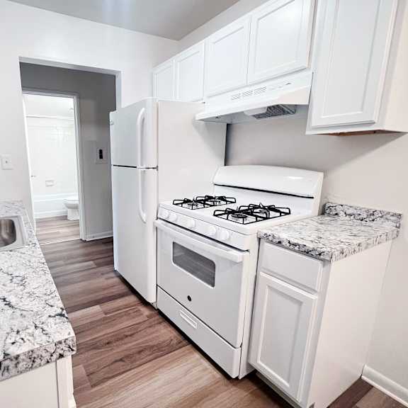 a kitchen with a granite counter top and white appliances.