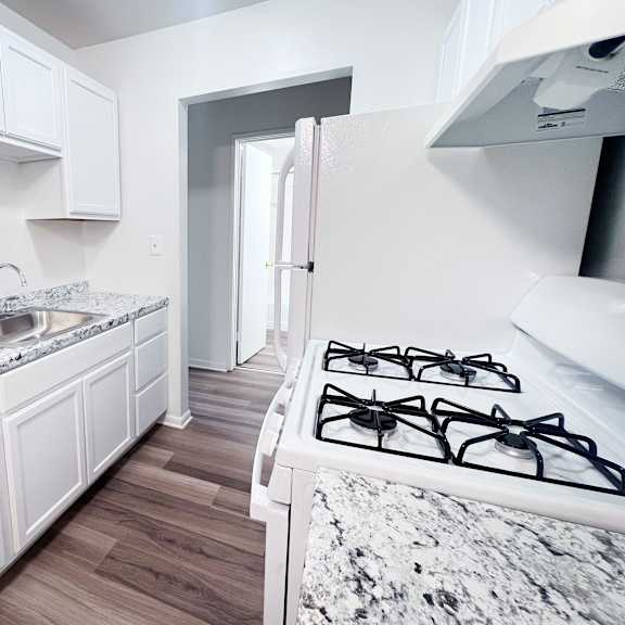 a kitchen with a marble countertop and white cabinets.