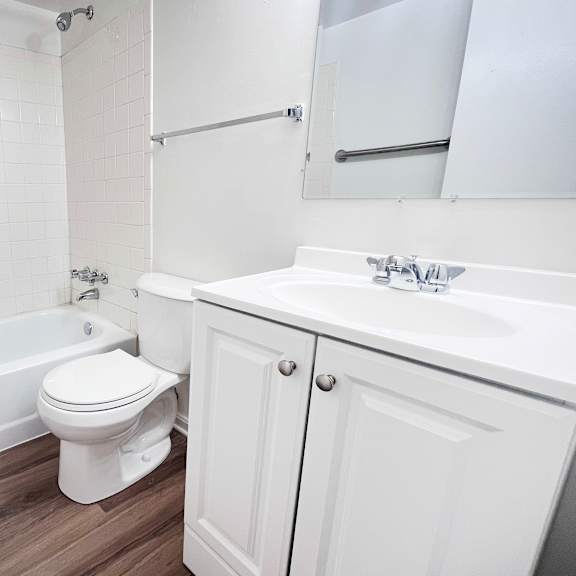 a white toilet sits next to a white sink in a bathroom.