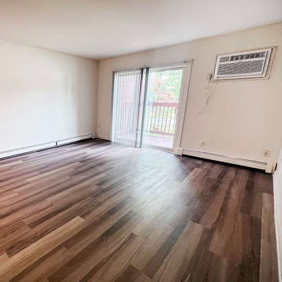 a room with wooden flooring and sliding glass doors.