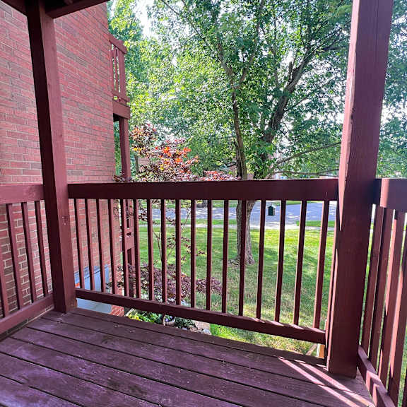 a wooden deck with a red brick building in the background.