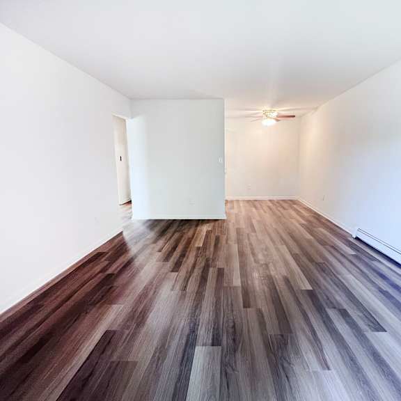 a room with a white wall and a wooden floor.